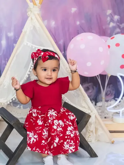 The baby girl looks curious and engaged during her princess-themed indoor photoshoot.