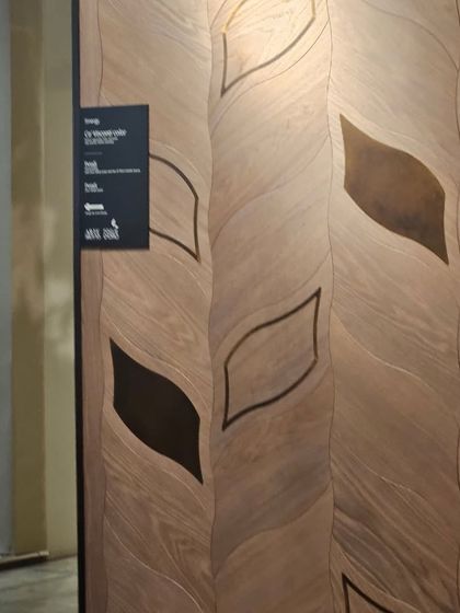 A wall panel featuring a leaf-patterned wood inlay. This artistic application of wood veneer shows our capability in creating detailed marquetry.
