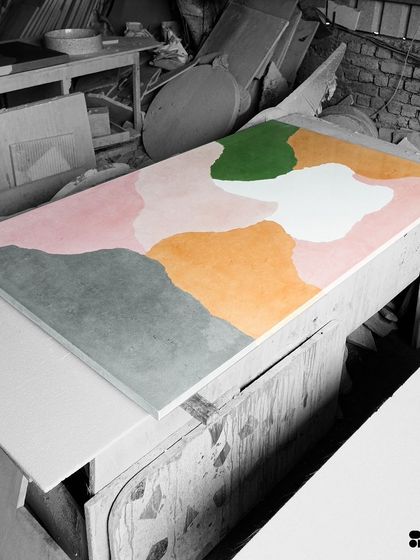 The multi-color concrete slab on a workshop table, waiting for the next stage of production. Each slab is a unique canvas, created by hand.
