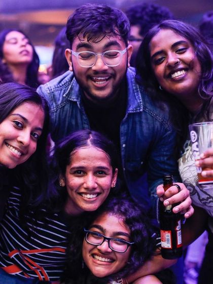 A happy group of friends huddling for a photo at Flo.