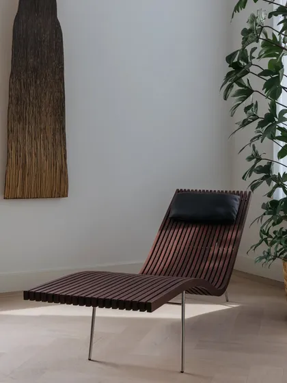A lounge chair designed by Peter Zumthor for Time & Style turns a simple corner into a destination for quiet repose. This piece was selected for its elegant form and craftsmanship, contrasting with the whitewashed oak floors.