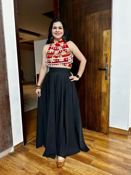 A festive look created by upcycling a saree blouse piece into a beautiful crop top, paired with a simple black skirt. This is a great way to create a Navratri or Garba outfit on a budget.
