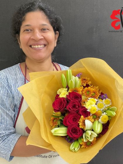 This student's hand-tied bouquet is bursting with the sunny colors of red roses, yellow lilies, and chrysanthemums. The spiral technique learned in class ensures every flower is perfectly placed.