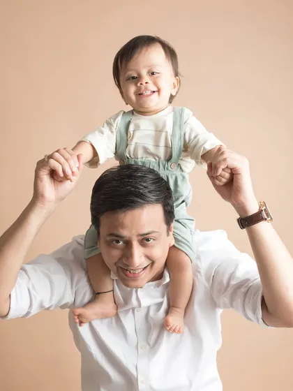 The best seat in the house! A happy son enjoys a ride on his father's shoulders.