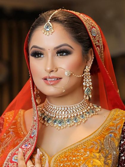 Transforming dreams into reality. This bride's look features a stunning combination of orange and maroon, with makeup that makes her skin radiate from within.