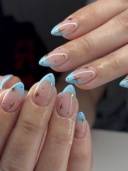 A playful and celestial-inspired design. This look features a trendy baby blue French tip on a neutral base, adorned with tiny gold stars for a touch of whimsy and magic.