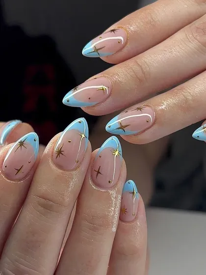 A dreamy, celestial-themed design. We hand-painted tiny gold stars over a baby blue French tip for a look that's perfect for stargazing on a clear night.