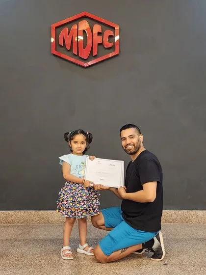 Another happy student receiving her certificate on International Dance Day.
