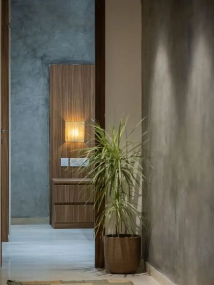 A corridor with grey oxide walls and warm wooden doors creates a moody and atmospheric transition space within the home.