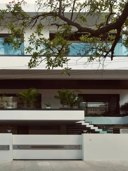 The facade of this modern villa features stacked horizontal volumes, with glass railings on the balconies ensuring unobstructed views and a feeling of lightness.