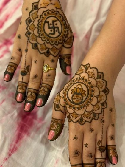 A simple yet beautiful design for a puja or festival, featuring auspicious symbols like the swastika and the 'kalash' (holy pot) within a mandala.