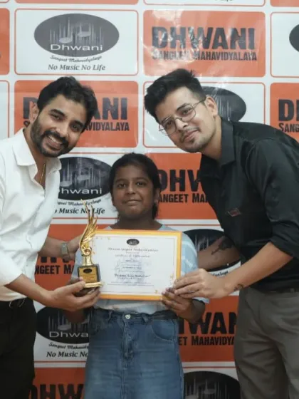 Two teachers present an award to a student.