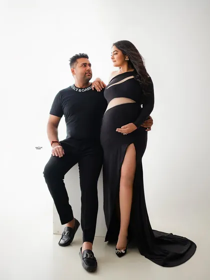 This couple's swag game is on point. A modern, high-fashion pose in all black, showing off their style and the beautiful baby bump.