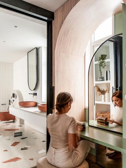 The dressing area in the master suite, with a vanity table framed by an arch, looks into the bright and airy bathroom.