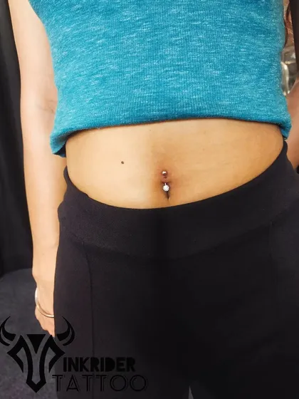 A full view of a client's new navel piercing. This shows how a belly piercing can complement your overall look.