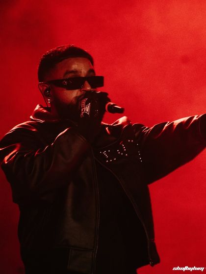 NAV performs under intense red stage lighting at Rolling Loud Mumbai. This close-up captures him in the middle of a verse, showcasing the raw energy of his set.