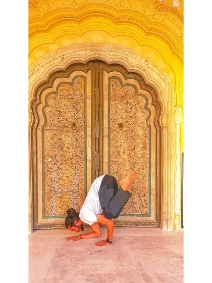 Another variation of Bakasana, showing a different leg position and demonstrating control.