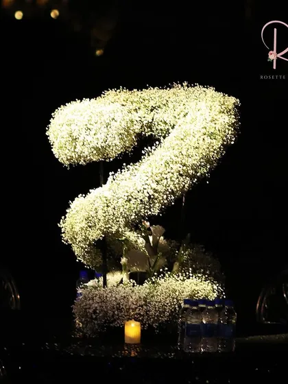 A centerpiece made from a large, S-shaped floral arrangement of baby's breath, showing my love for creating unique, sculptural floral designs.