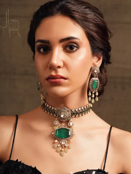 A close-up of the emerald and polki necklace set worn by Surveen Chawla, showcasing its intricate design and vibrant gemstones.