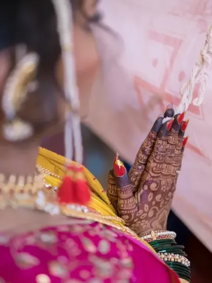 A close-up on the bride's hands in prayer, showcasing her intricate henna and the solemnity of the moment.