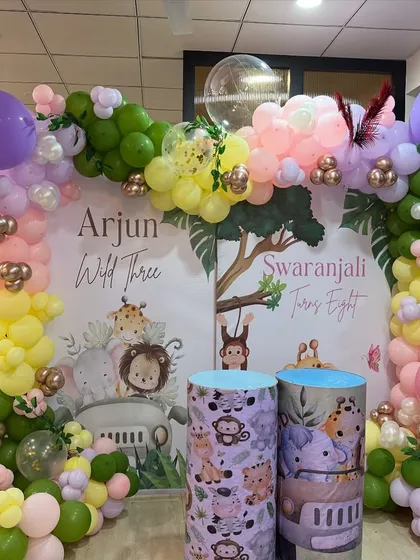 A joint birthday celebration for Arjun and Swaranjali with a pastel jungle theme. We created two distinct backdrops united by a single, colorful balloon arch.