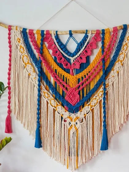This is my "DAHILA" wall hanging, a large and vibrant statement piece designed to bring color and life to any room. It's made with layers of intricate knots and soft cotton cord on natural driftwood, perfect for a living room or even as a unique wedding backdrop.