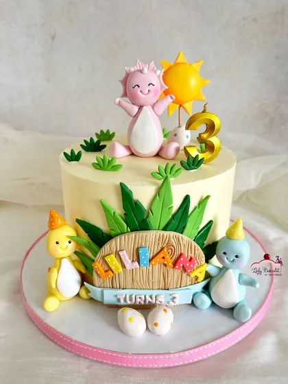A closer look at the main dinosaur cake, featuring cute, pastel-colored dinos.