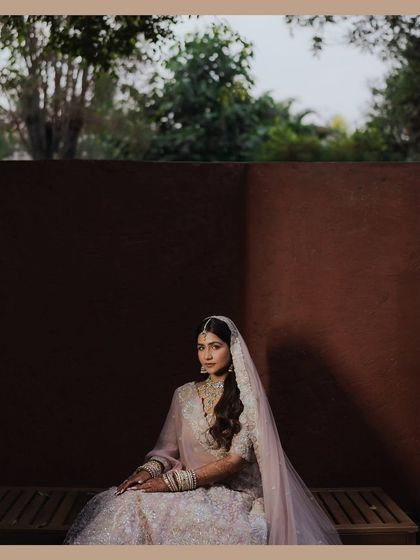 A beautiful portrait of the bride sitting in the shadows, the light catching her face perfectly. The dramatic lighting and her serene pose create a powerful and artistic image.