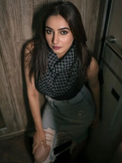 A moody, high-angle shot taken in a confined space, likely a vanity van. The lighting and composition create an intense and intimate portrait, showcasing a more edgy, urban style.