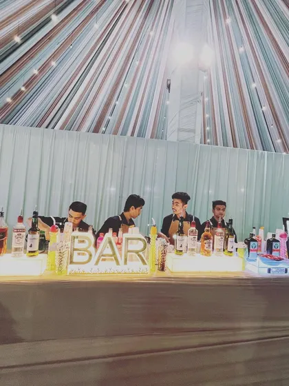 Our team of professional bartenders working together to manage a busy bar at a large wedding. We ensure quick and friendly service so your guests spend less time waiting and more time celebrating.
