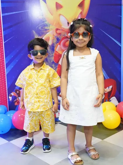 Two cool kids in sunglasses pose in front of a Sonic the Hedgehog backdrop. We can create parties based on any popular character.