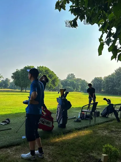 A quiet moment on the range. A few friends, their golf bags, and an open field to work on their swings.