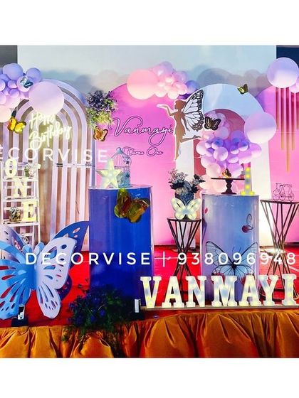 A closer look at Vanmayi's butterfly-themed first birthday stage. We used a mix of pink and lavender balloons, large butterfly cutouts, and a personalized photo board to celebrate her special milestone.