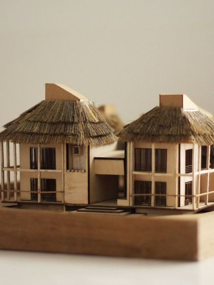 A detailed architectural model for the 'Serenity' guesthouse project. The use of wood and a thatched roof explores a more traditional and rustic material palette.
