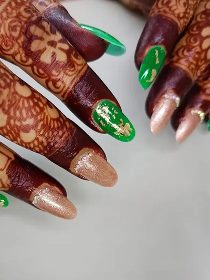 A closer look at this custom bridal set, showing the detail of the gold foil on the green nails and the subtle sparkle on the neutral nails.