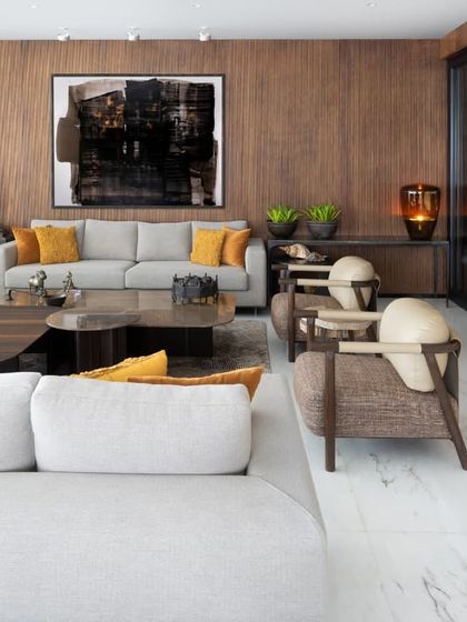 A closer look at the seating arrangement in the Camellias living room, where our custom-designed armchairs with unique leather detailing stand as functional sculptures. The mix of textures, from the woven fabric to the smooth wood and metal, is central to our design ethos.