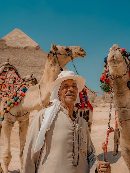 A portrait of an Egyptian camel handler at the Giza pyramids. His weathered face and traditional clothing tell a story of a life spent in the shadow of ancient wonders.