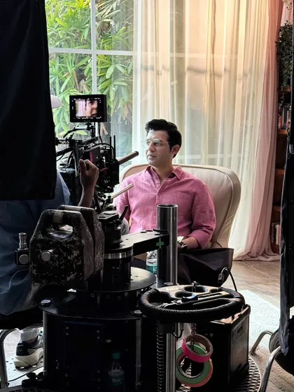 In position and ready for the camera to roll. This shot gives a sense of the professional lighting and camera setup used in commercial productions.