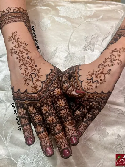 A delicate and modern design for a Roka ceremony. This mehendi features beautiful lotus patterns on the palm with a minimalist vine design on the back of the hand, including the couple's initials.