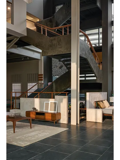 A view from the ground floor of the Magari store, looking up at the sculptural ferrocement staircase that connects the different levels of the showroom.
