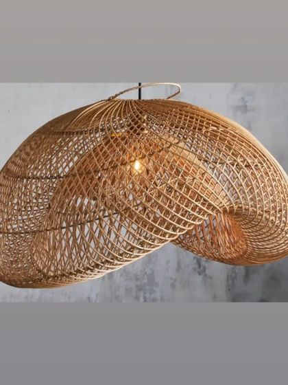 This organically shaped, handwoven rattan pendant light showcases a complex, grid-like weave. The light filters through the gaps to create a soft, diffused glow, ideal for creating a relaxed atmosphere in a lounge or bedroom.