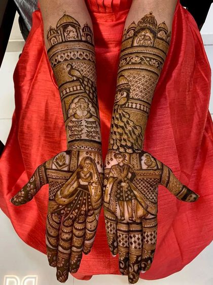 This design features a classic bride and groom portrait on the palms, framed by intricate peacock and palace motifs on the forearms.