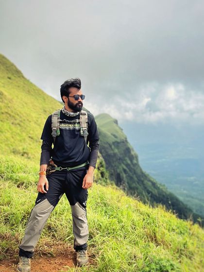 A trekker poses on the Bandaje trail, looking out at the stunning view.
