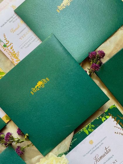 The emerald green invitation folder with the couple's names in gold-foiled script. This piece is both luxurious and deeply meaningful, reflecting the sacredness of the ceremony.