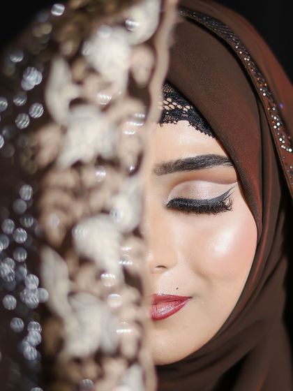 A creative shot with the hijab partially covering the face, drawing all attention to the intricate eye makeup.