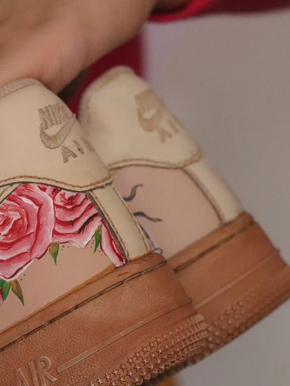 A close-up of the heel of the tea-dyed AF1s, showing the delicate rose paintings. The tea provides a softer, lighter vintage tone compared to coffee.