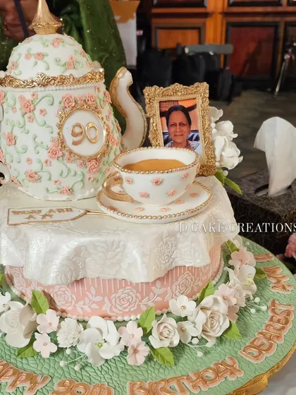 This custom teapot cake was designed for the 90th birthday of Aamir Khan's mother. The design features delicate, hand-painted floral patterns and a framed photo, making it a deeply personal and elegant centerpiece.