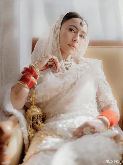 A soft and dreamy close-up of Sejal. The light filtering through the window and the delicate details of her jewelry and outfit create an ethereal, almost painterly quality in this bridal portrait.