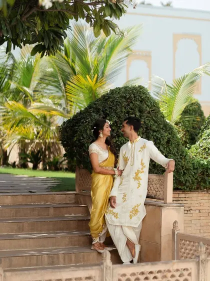 The couple posing on the steps of the beautiful Radisson Blu Udaipur. The venue's architecture provides a stunning backdrop for pre-wedding photos.