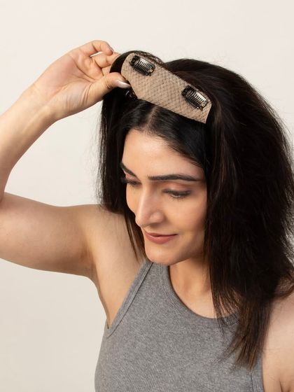 A model demonstrating the placement of a hair topper with clips.